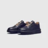 genuine leather platform sneakers in black, front 45-degree view of the pair on a light gray background