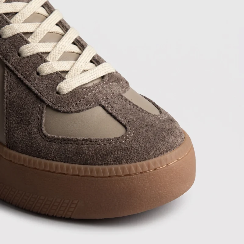 retro platform german trainer sneakers in brown, close-up view of the toe on a light gray background