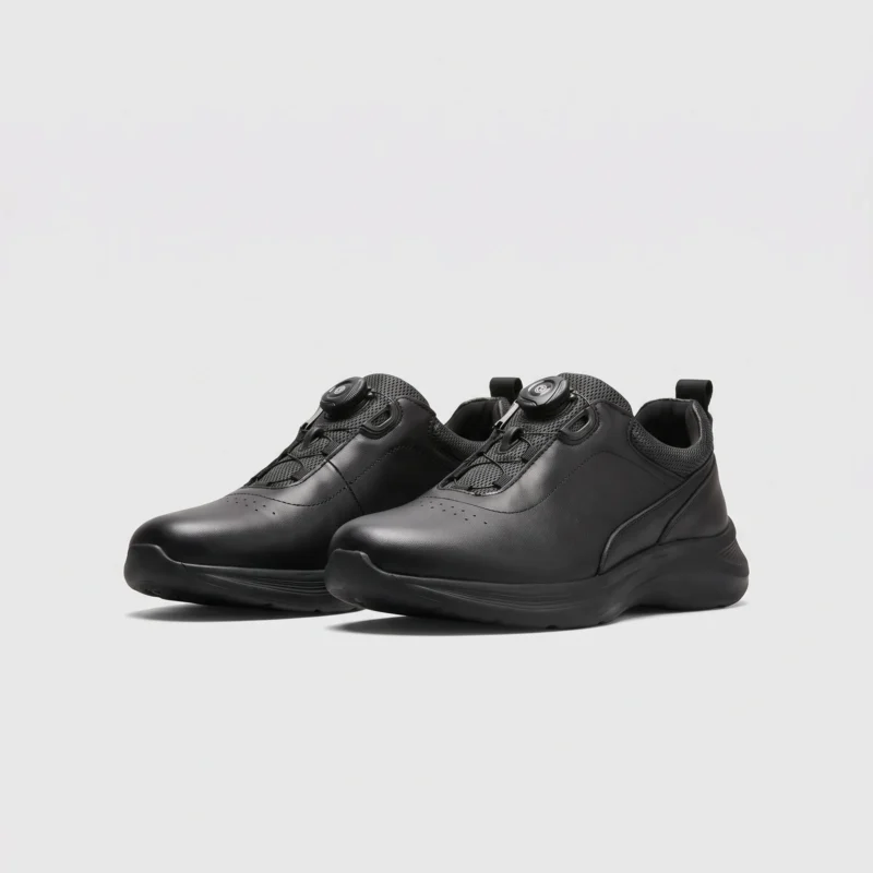 genuine leather rotating dial casual sneakers breathable lightweight in black, front 45-degree view of the pair on a light gray background