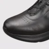 genuine leather rotating dial casual sneakers breathable lightweight in black, close-up view of the toe on a light gray background