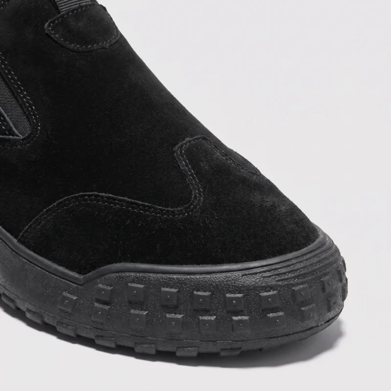 slip-on work safety shoes lightweight suede anti-slip driving shoes in black, close-up view of the toe on a light gray background