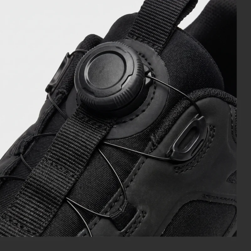 trendy rotating dial closure casual sneakers breathable chunky sole commuter shoes in black, close-up view of the closure on a light gray background