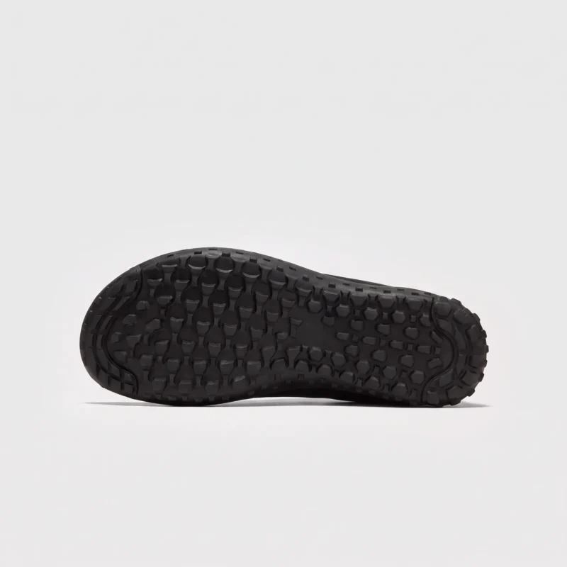 wide toe box barefoot hiking sneakers in black, outsole tread view on a light gray background