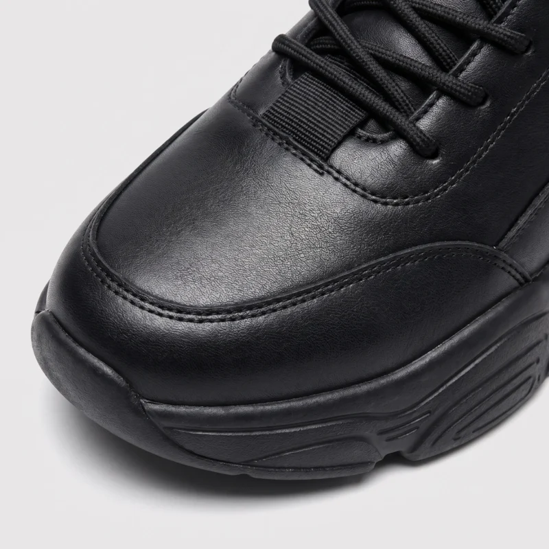 leather breathable hiking walking shoes lightweight non-slip outdoor sneakers in black, close-up view of the toe on a light gray background